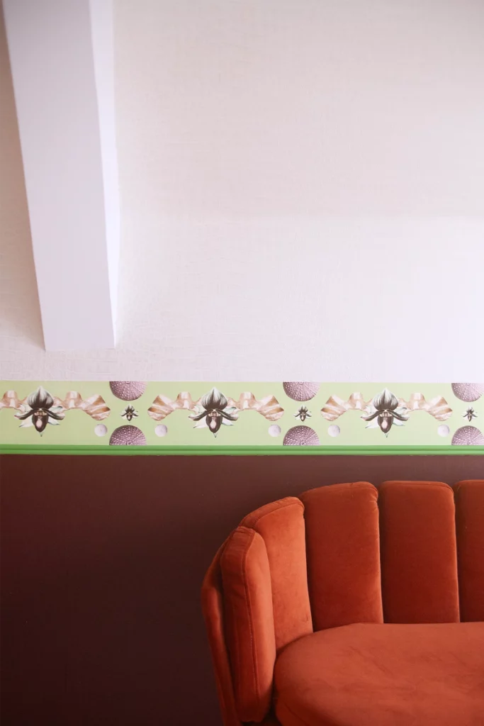 Frise murale dans une chambre, composition colorée en papiers, vue de face de la pièce.