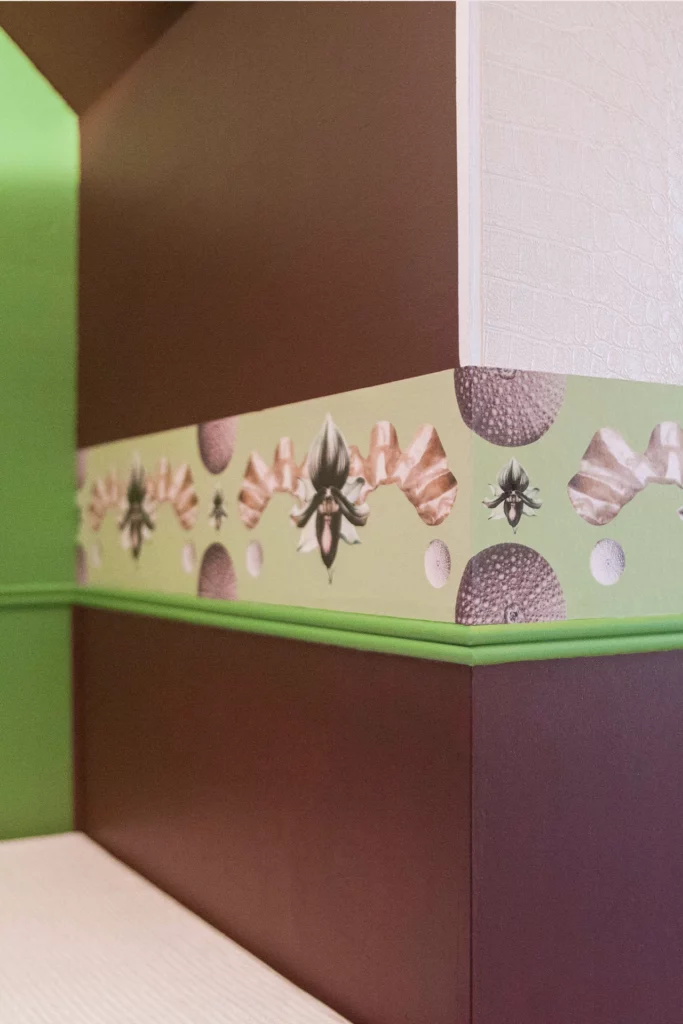 Frise murale en collage dans une chambre, composition colorée en papiers et textures, angle de la pièce.